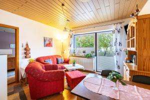 sala de estar con sofá rojo y mesa en Heidi en Tönning