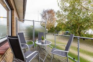 eine Terrasse mit 3 Stühlen und einem Tisch auf dem Balkon in der Unterkunft Heidi in Tönning