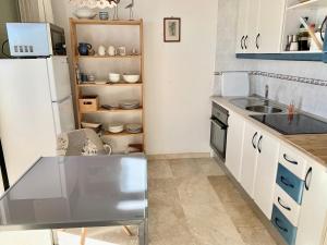 Apartamento Cielo Azul في روكويتاس دي مار: مطبخ مع مغسلة وثلاجة