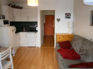 un salon avec un canapé et une cuisine dans l'établissement Coquet studio à Le Dévoluy de 24 m², à Saint-Étienne-en-Dévoluy