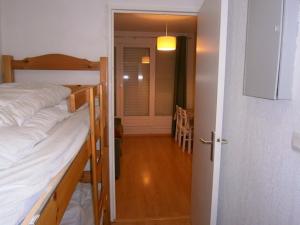 une chambre avec deux lits superposés et un couloir dans l'établissement Coquet studio à Le Dévoluy de 24 m², à Saint-Étienne-en-Dévoluy