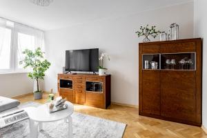 a living room with a television and a table at Hala Mirowska Apartments in Warsaw