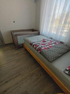 niewielka sypialnia z łóżkiem i oknem w obiekcie Domček v záhrade w Liptowskim Mikulaszu