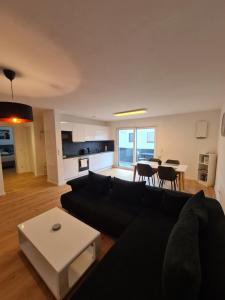 a living room with a black couch and a table at Panorama Apartments in Füssen