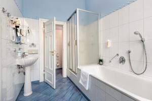 Baño blanco con bañera y lavamanos en Schlosshotel Ralswiek, en Ralswiek