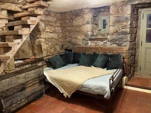 uma cama num quarto com uma parede de pedra em Domaine de la coletta Maison traditionnelle em Coti-Chiavari