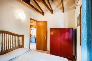 1 dormitorio con 1 cama y armario de madera en La Baita del Convento - Il tuo rifugio sull'Etna, en Nicolosi