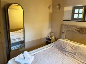 una camera da letto con un letto e un grande specchio di Domaine de la Coletta. Bergerie. Plage privative a Coti-Chiavari