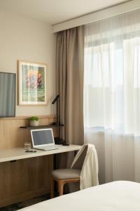 a bedroom with a desk with a laptop and a window at Crowne Plaza Budapest, an IHG Hotel in Budapest