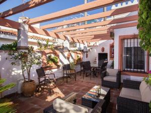 an outdoor patio with chairs and tables and a pergola at Holiday Home Mijas-Costa near Beach in La Cala de Mijas