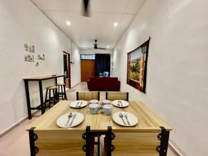 大山腳的住宿－Cozy 255 Entire 3 Bedroom House At Alma Bukit Mertajam，一间带木桌和椅子的用餐室