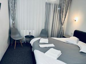 um quarto de hotel com uma cama e duas cadeiras em Pensiunea La Brazi em Manastirea Humor