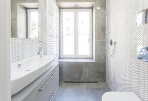 a white bathroom with a sink and a shower at TurnKey I Studio by Amazing Park in Prague