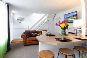 a kitchen and living room with a table and chairs at Modern Quirky Exeter City Cottage 2 min walk - shops in Exeter