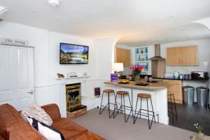 a living room with a couch and a kitchen at Modern Quirky Exeter City Cottage 2 min walk - shops in Exeter