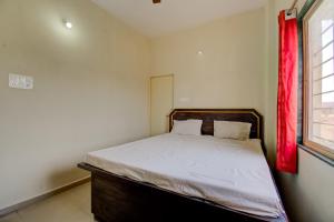 una camera con letto con tenda rossa di SPOT ON R D Homestay 1 a Dispur