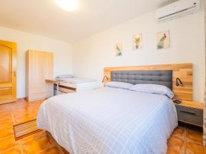 a bedroom with a bed with a blue and white comforter at Cubo's Sporting Villa Paloma in Villafranco de Guadalhorce +34 photos