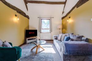 a living room with two couches and a tv at Finest Retreats - Idris Barn Helm y Llwyn Barn in Dolgellau