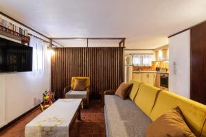 a living room with a yellow couch and a kitchen at Beach Front Vintage Villa Kalliktratis in Nea Kalikratia