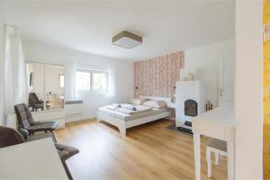 a white room with a bed and a fireplace at Old Nest Mogyoród in Mogyoród