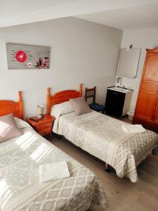 a bedroom with two beds and a table at PENSIÓN PESQUERO in Burgos