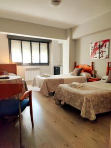 布爾戈斯的住宿－PENSIÓN PESQUERO，酒店客房设有三张床和窗户。