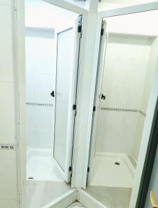 een badkamer met een douche en een glazen deur bij PENSIÓN PESQUERO in Burgos