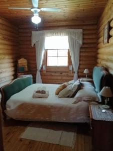 a bedroom with a large bed in a log cabin at Casa De Madera, A home from home. in Teresa de Cofrentes