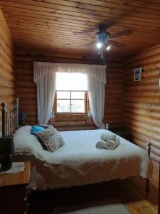 a bedroom with a bed in a log cabin at Casa De Madera, A home from home. in Teresa de Cofrentes
