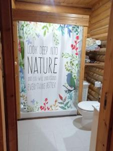 a bathroom with a toilet and a shower curtain at Casa De Madera, A home from home. in Teresa de Cofrentes