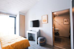 a hotel room with a bed and a television at L'envie in Saint-Gilles-Croix-de-Vie