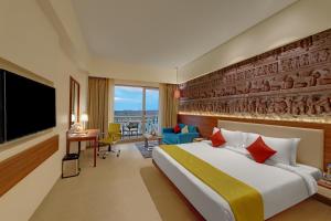 een hotelkamer met een bed en een flatscreen-tv bij The Fern Sattva Resort, Dwarka in Dwarka