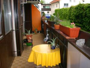 シュピーゲラウにあるFerienwohnung Haniの植物のあるバルコニーの小さな黄色いテーブル