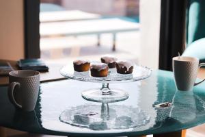 a tray with three donuts on a table with two cups at L'envie in Saint-Gilles-Croix-de-Vie