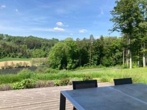 a table and chairs on a deck with a view of a golf course at Vulkanland Stoeckel - Feldbach in Feldbach