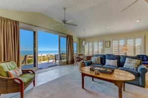 a living room with a blue couch and a table at Fletcher Family Friendly Home in Fernandina Beach