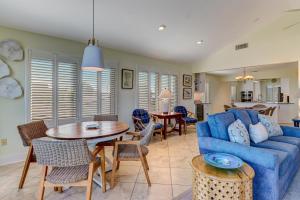 a living room with a blue couch and a table and chairs at Fletcher Family Friendly Home in Fernandina Beach