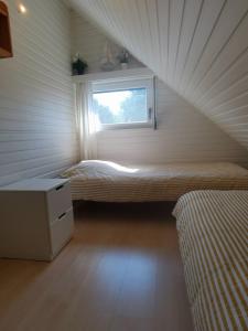 um pequeno quarto com uma cama e uma janela em Seaside em Middelkerke