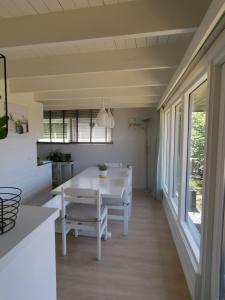 uma cozinha e sala de jantar com uma mesa branca e cadeiras em Seaside em Middelkerke