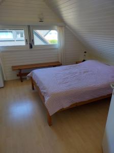 a bedroom with a bed and a bench and a window at Seaside in Middelkerke