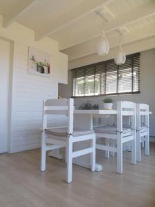 ein weißes Esszimmer mit einem weißen Tisch und Stühlen in der Unterkunft Seaside in Middelkerke