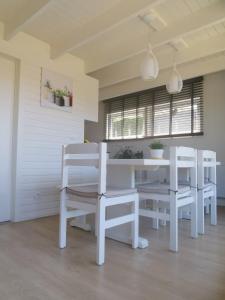 a white dining room with a white table and chairs at Seaside in Middelkerke +15 photos