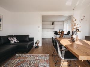 a living room with a black couch and a wooden table at Das Dietrich - Landhaus 58 in Leibnitz