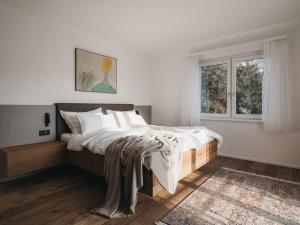 Un dormitorio con una cama con paredes blancas y una ventana en Das Dietrich - Landhaus 58, en Leibnitz