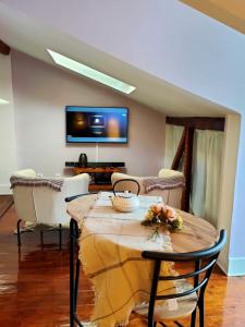ein Wohnzimmer mit einem Tisch mit Stühlen und einem TV in der Unterkunft Casa Shardana Lisbon in Lissabon