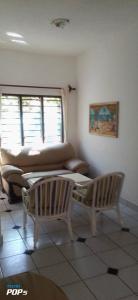 a living room with a couch and two chairs at Diani Horizon Beach Cottages in Diani Beach