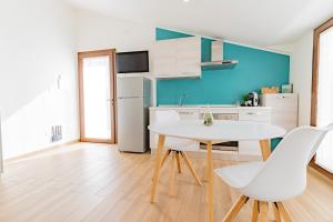 a kitchen with a white table and white chairs at Lumen House in Sassari