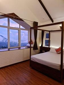 a bedroom with a canopy bed and a large window at Sky Sketch in Kodaikānāl