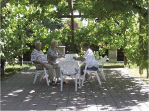three people sitting at a table in a park at Appartement Haus Salzburg in Bad Füssing