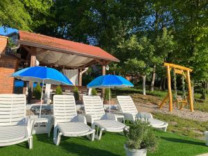 a group of chairs and umbrellas in a yard at Jezero Sniježnica - Vikendica in Sniježnica